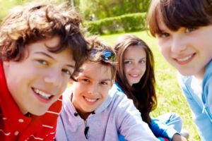 Portrait of happy teens looking at camera in the park at summer