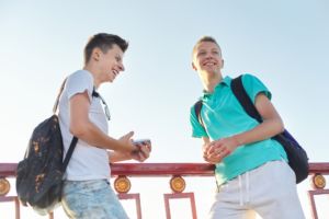 Outdoor portrait of two talking boys teenagers 15, 16 years old