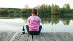 Young city resident enjoy the tranquility on a pier near the pond